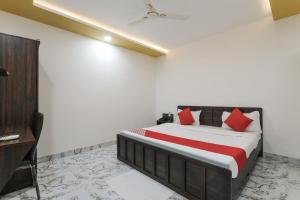 BijnaurHotel O Aastha Near Chaudhary Charan Singh International Airport的一间卧室配有红色枕头的床