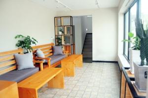 GongjuEin House的一间设有两个木长椅和盆栽的房间