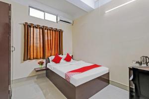 DispurOYO Flagship Lucky 7的一间卧室配有一张带红色枕头的床和一扇窗户
