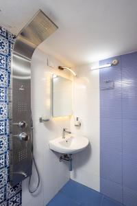 科钦Paradise Inn的一间带水槽、镜子和淋浴的浴室