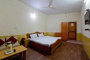 ShamshiOYO Hotel Sunbeam的一间卧室配有一张床和一张沙发