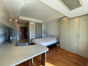 北京Beijing Elegant Seasons Park Apartment的一间卧室配有一张床和一张书桌