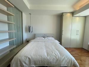 北京Beijing Elegant Seasons Park Apartment的卧室配有一张白色大床和橱柜。