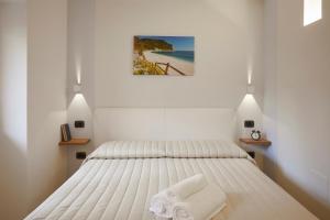 锡罗洛Affittacamere Somnium的白色卧室,配有带毛巾的床