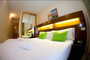 圣马丁德拉韦加Hostal San Marcos的卧室配有带绿色枕头的大型白色床