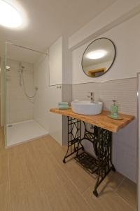 BeilingenCasa Eifel的浴室配有盥洗盆和带镜子的淋浴