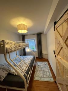 BeilingenCasa Eifel的一间卧室设有一张双层床和一扇木门。