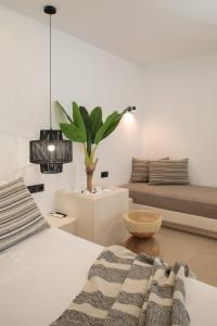 纳克索乔拉Naxos Village hotel的一间卧室配有一张床和盆栽植物