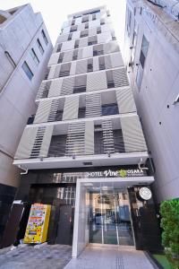 大阪大阪北浜VINE酒店的一座大型建筑,前面设有酒店入口