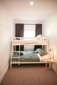 克莱斯韦克Enjoy a renovated retreat with outdoor bath的一间卧室设有两张双层床和一扇窗户。