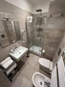 巴勒莫Maqueda Suites的一间带水槽、淋浴和卫生间的浴室