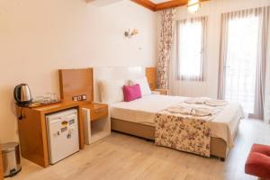 阿奇亚卡MANDALİN AKYAKA的一间卧室配有一张床,并在一间客房内配有电视。