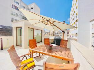 马略卡岛帕尔马Hotel-Apartment with big terrace的阳台配有桌椅和遮阳伞