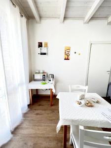 奥斯图尼Il Girasole的白色的客房设有2张桌子和微波炉