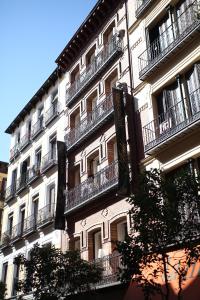 马德里AB设计套房公寓式酒店的一座高大的建筑,旁边设有阳台
