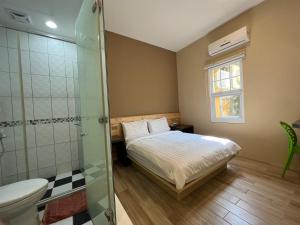 小琉球岛好樣的民宿的一间卧室设有一张床和一个玻璃淋浴间