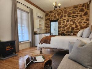 MaranangaMarananga Cottages的一间卧室设有石墙、一张床和一个壁炉