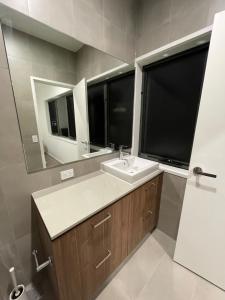 黄金海岸Comfortable 2 Story Villa next to a Canal的一间带水槽和镜子的浴室