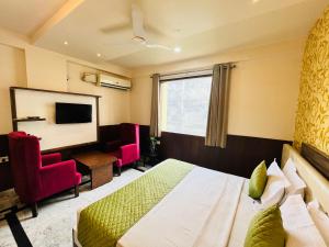 勒克瑙Hotel The Leaf - Gomti Nagar Lucknow的一间酒店客房,配有一张床和一台电视