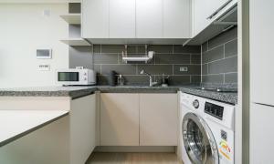 仁川市Urbanstay Songdo Moonlight Park的厨房配有洗衣机和洗衣机。