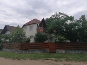 瓦沙罗什瑙梅尼Sarkifény Vendégház的木栅栏后面的房子