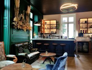 拉贝尔讷里昂雷茨Domaine de La Gressière的一间酒吧,拥有绿色的墙壁和桌椅