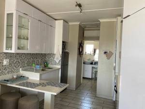 马盖特Uvongo Chalet 11的厨房配有白色橱柜和台面
