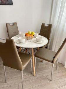 里耶卡Adria Sky的一张带椅子的白色桌子和一碗水果