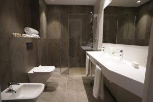纳瓦雷特Hotel Bodega FyA - GRUPO PIÉROLA的一间带两个盥洗盆、淋浴和卫生间的浴室