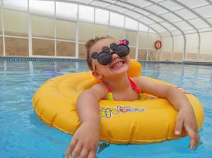 托里什韦德拉什Dii Beach House - Casa de Férias com piscina interior aquecida的穿着眼镜的游泳池里的年轻女孩