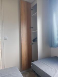 瓦尔拉普拉日MOBIL HOME DU ROUTIER的一间卧室配有一张床和一扇木门