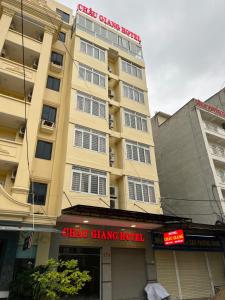 格卢市社Châu Giang Hotel Cửa Lò的一座黄色的大建筑,上面有标志