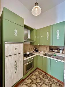 莫诺波利La Vitagira的厨房配有绿色橱柜和炉灶。 顶部烤箱