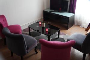 波尔多Appartements Victor et Hugo的客厅配有椅子、桌子和电视