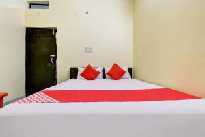 BankipurHotel Basera的一间卧室配有一张带红色枕头的大床