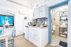 奥斯图尼Vico di Ostuni Apartments by Rentbeat的厨房配有白色橱柜和蓝色门