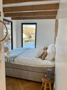 蒙尼肯丹Luxury Houseboat Liberdade with sauna and dinghy的一间卧室设有一张大床和大窗户