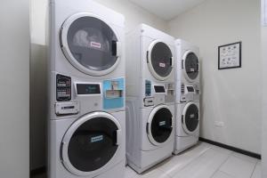 新加坡哈夫洛克路易凯恩服务公寓式酒店的墙上洗衣房的三台洗衣机