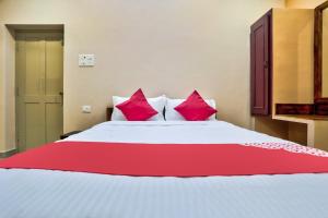 蓬蒂切里Sri Abirami Inn的卧室配有一张带粉红色枕头的大床