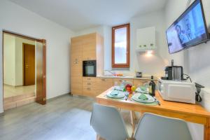 门德里西奥Mendrisio Corte - Happy Rentals的厨房配有木桌、椅子和微波炉