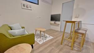永康寓見南台假日公寓 的客厅配有绿色沙发和桌子