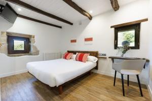 宏达瑞比亚阿洛特森尼亚乡村旅馆的一间卧室配有一张床、一张桌子和一把椅子