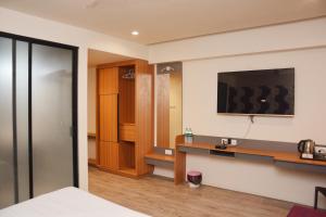 舍地HOTEL SAI PALKHI NIWARA的酒店客房设有一张桌子和一台墙上的电视。