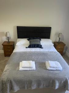 IrvinestownThe Garden House, Necarne, Irvinestown的一间卧室配有一张大床和两条毛巾