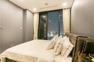胡志明市Jessie Apartment - Infinity pool - Rivergate Residence的一间卧室设有一张大床和大窗户