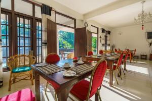 乌纳瓦图纳Abundia Unawatuna的一间设有红色椅子和桌子的用餐室以及窗户。