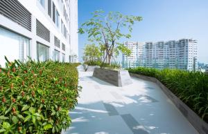 胡志明市Jessie Apartment - Infinity pool - Rivergate Residence的一条种植了植物的建筑旁的走道