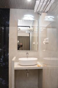 舍地HOTEL SAI PALKHI NIWARA的一间带水槽和镜子的浴室