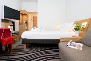 米兰诺富特米兰诺德卡格兰达酒店的酒店客房设有一张大床和一张沙发。