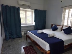 海得拉巴Deccan Stay的一间卧室配有2张蓝色窗帘